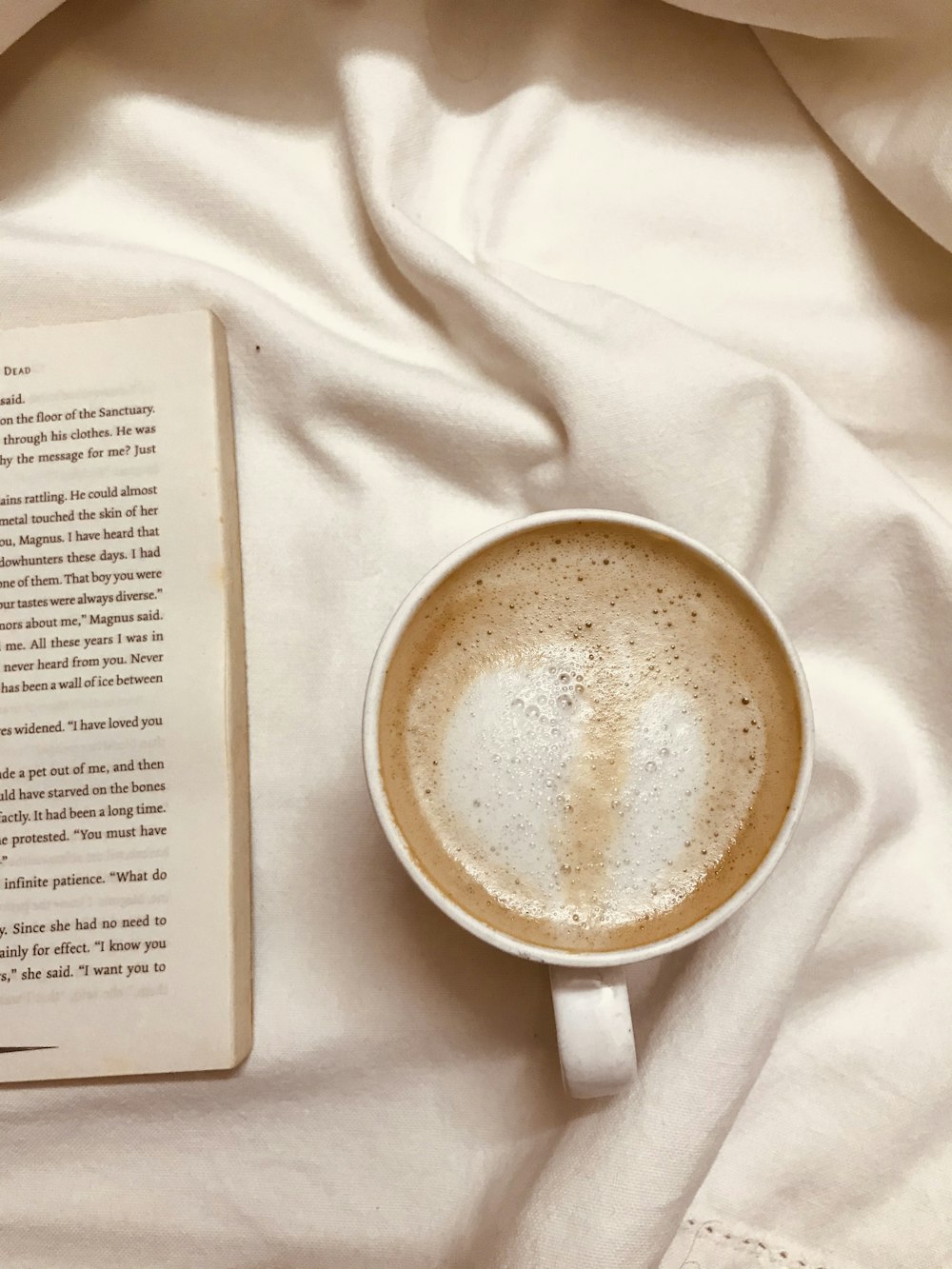 white ceramic mug on white textile