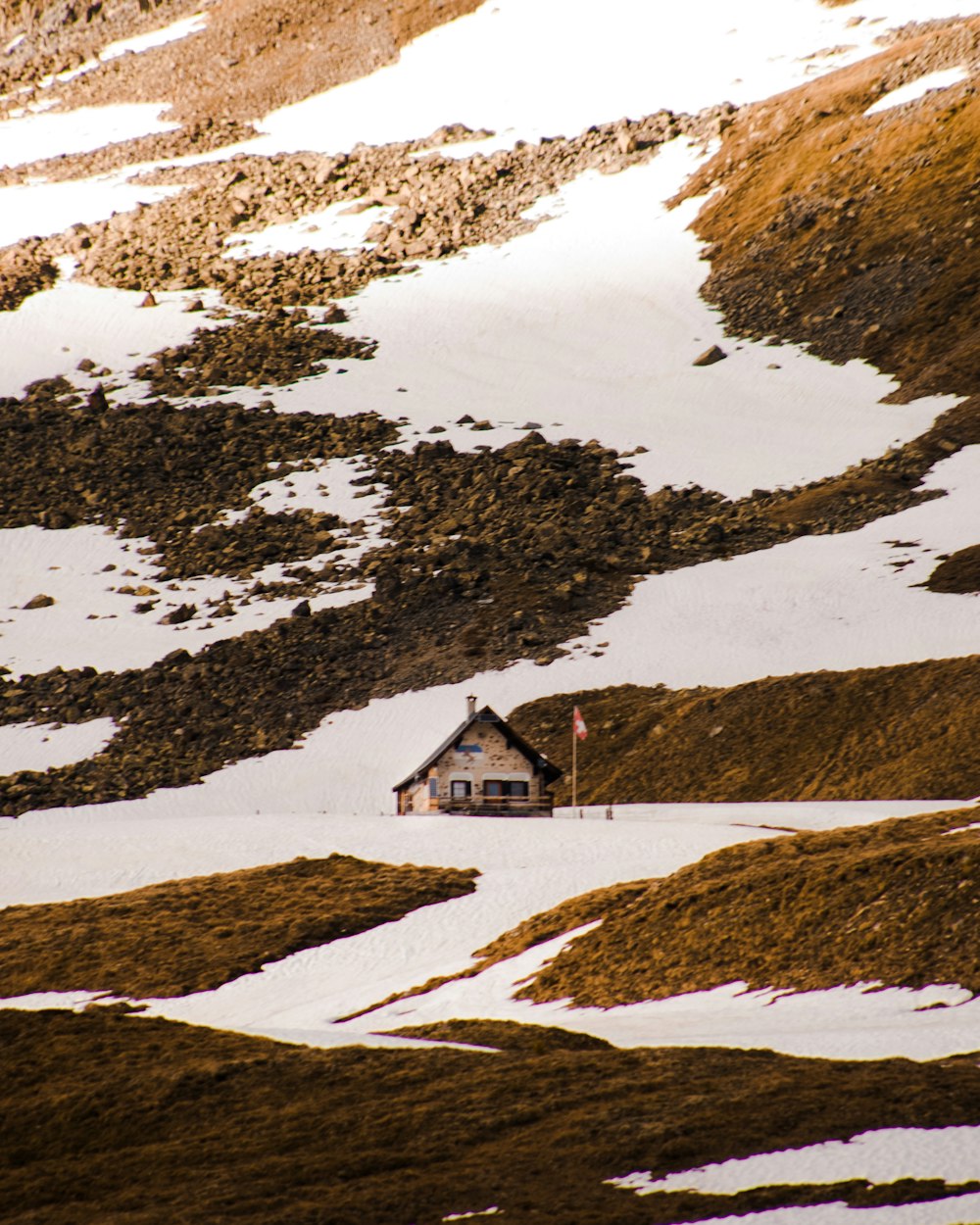 Casa blanca y marrón en campo marrón cubierto de nieve