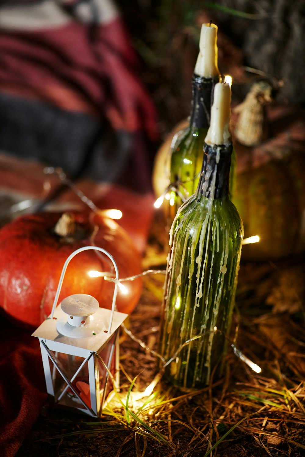 green glass bottle beside lighted candle