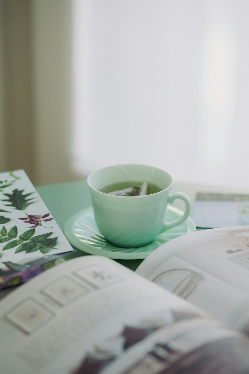 white ceramic mug on white and green floral ceramic saucer