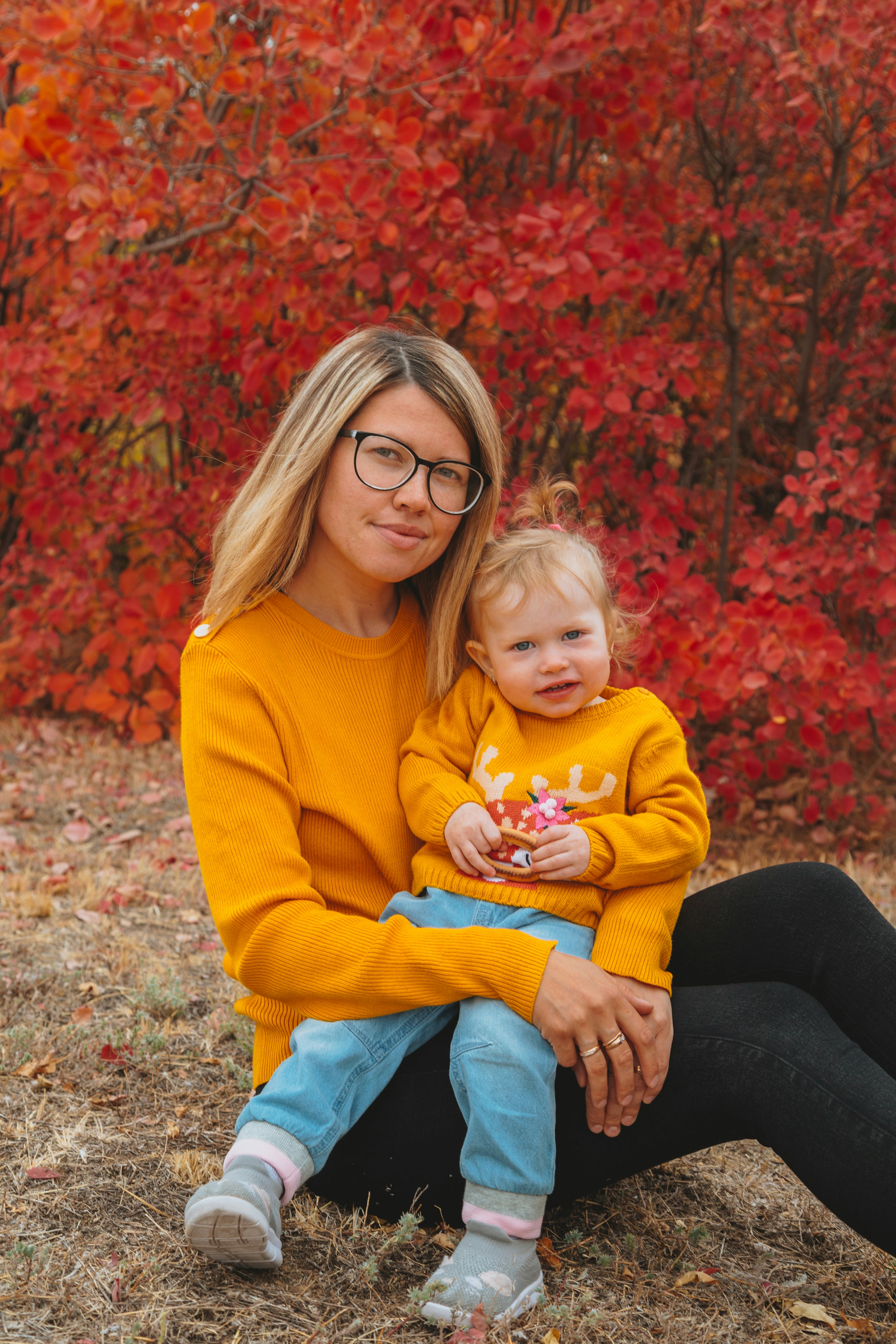 Wanita dengan sweter kuning membawa gadis dengan sweter kuning