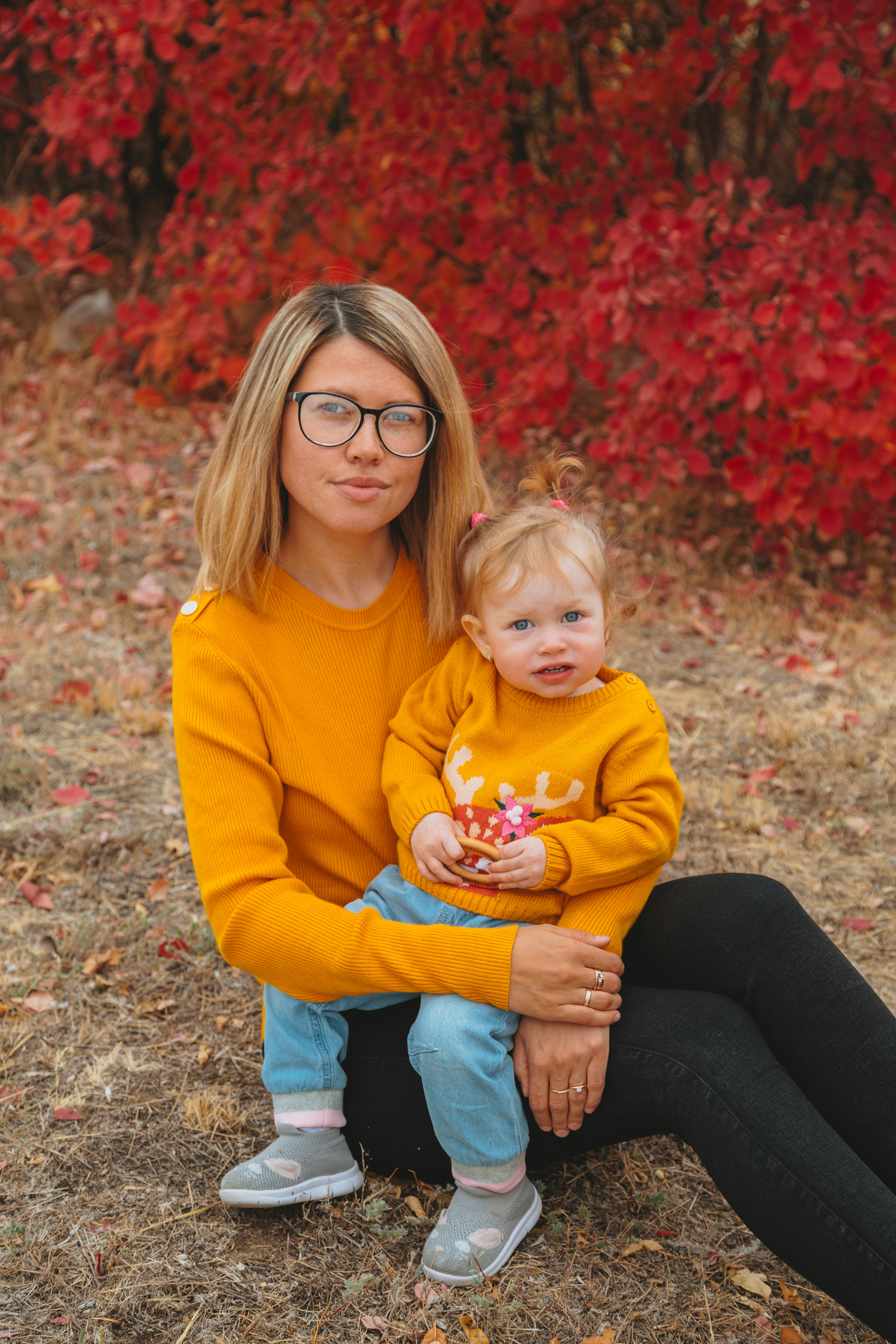 wanita dengan sweter kuning menggendong bayi dengan sweter kuning