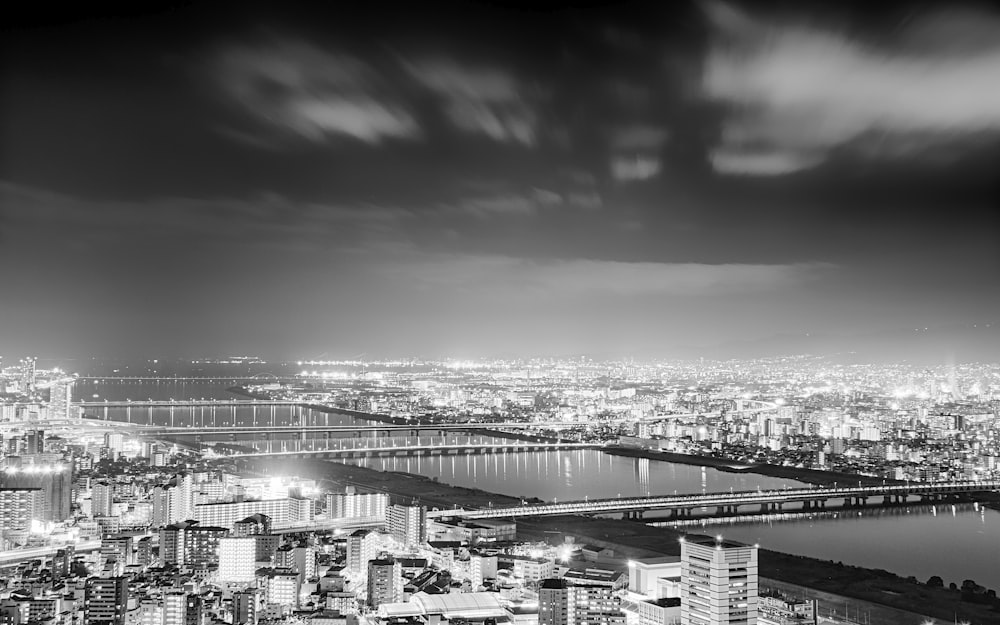 grayscale photo of city buildings near body of water