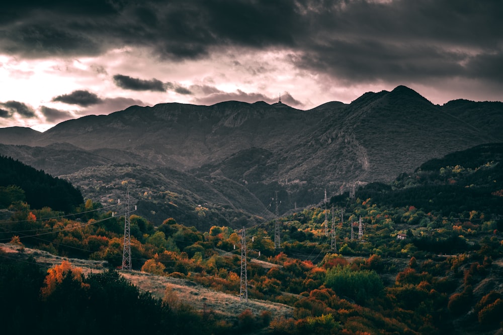 árvores verdes e montanhas sob o céu nublado durante o dia