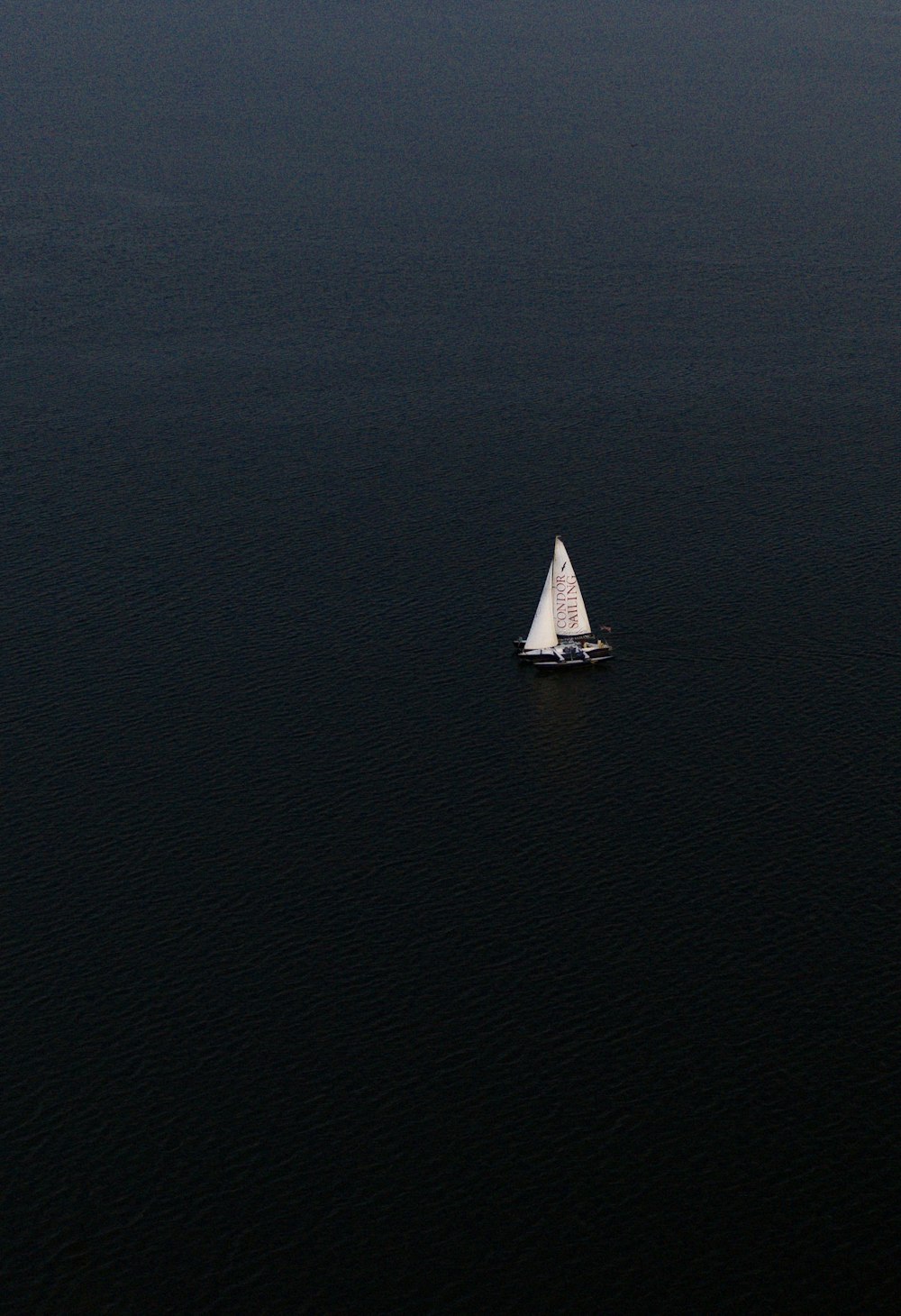 barca a vela bianca sullo specchio d'acqua durante il giorno