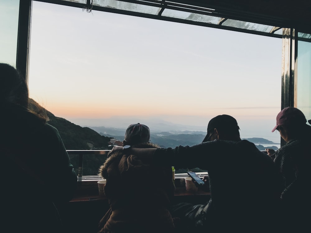 silhouette of people standing on bridge during sunset