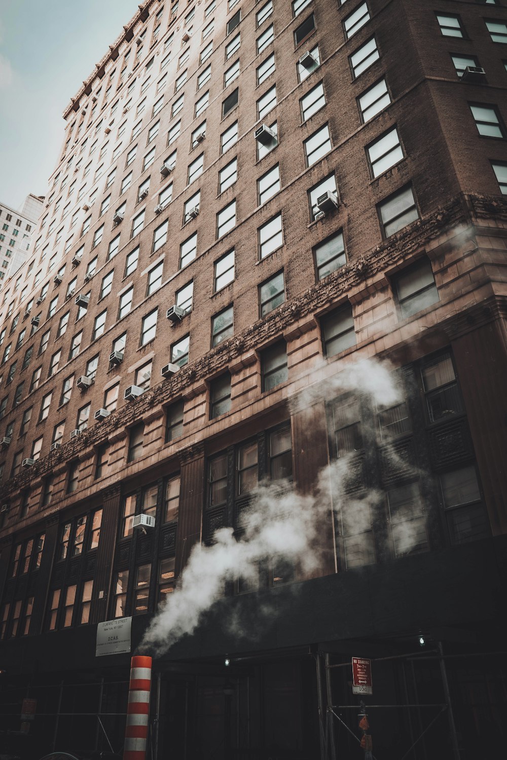 edificio in cemento marrone con fumo