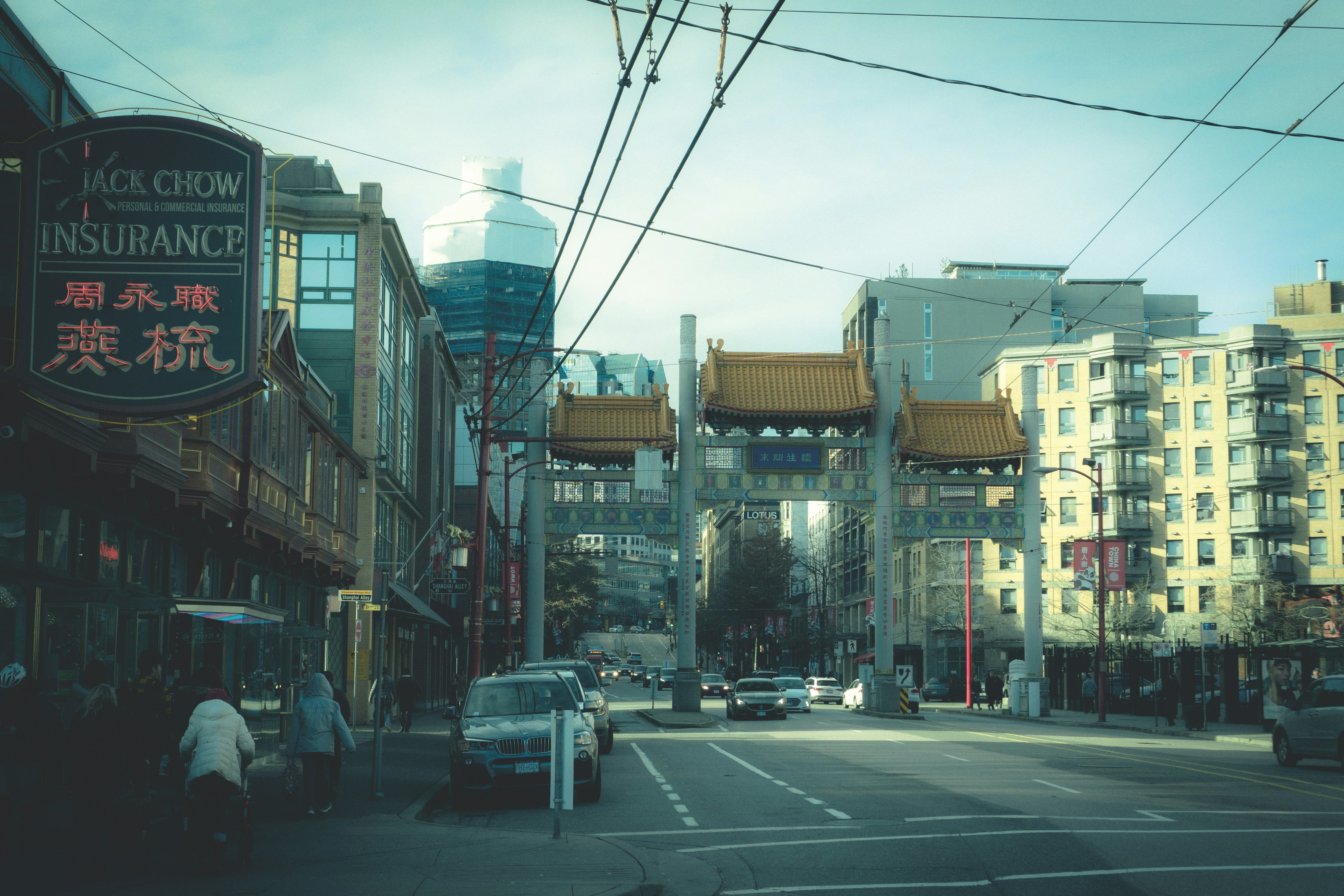 cars parked on side of the road in between buildings during daytime