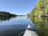 A kayak gliding through the lush green mangrove of Génipa under a bright sky.