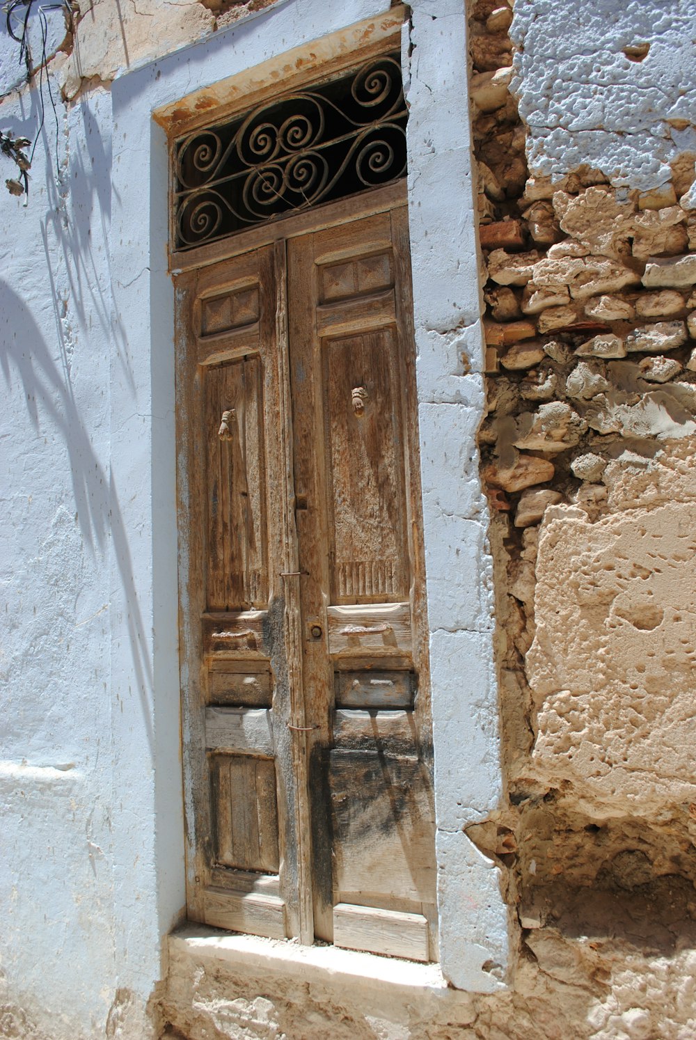 brown wooden door on white concrete wall