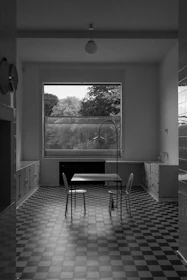 Minimalist icon representing a magnifying glass over a kitchen layout.