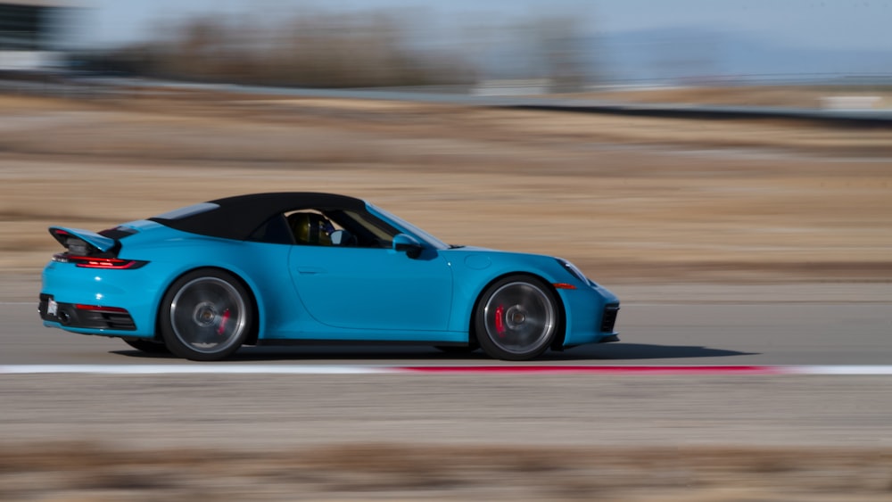 blue convertible coupe on road