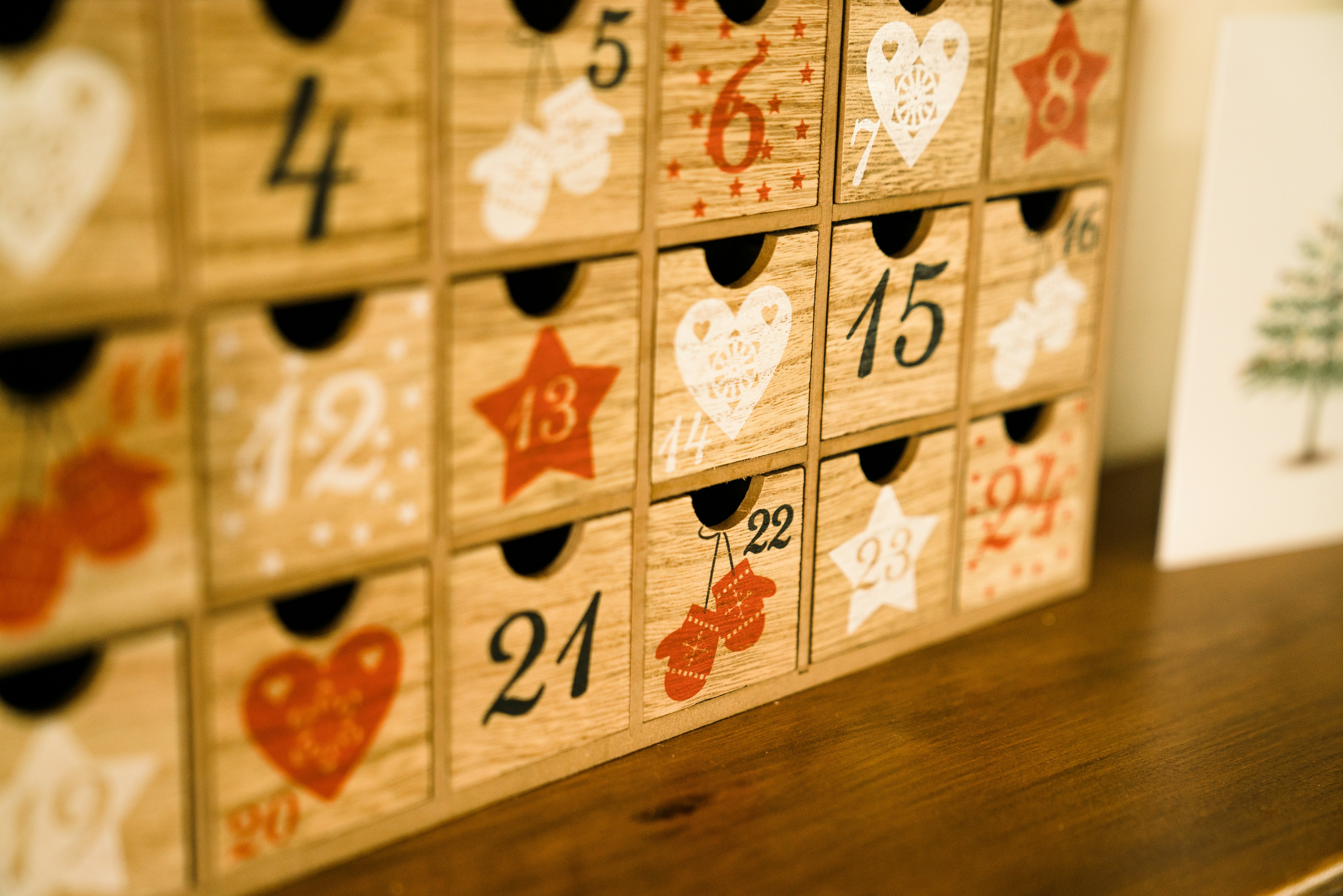 Rustic wooden advent calendar with 24 numbered drawers decorated with snowflake carvings