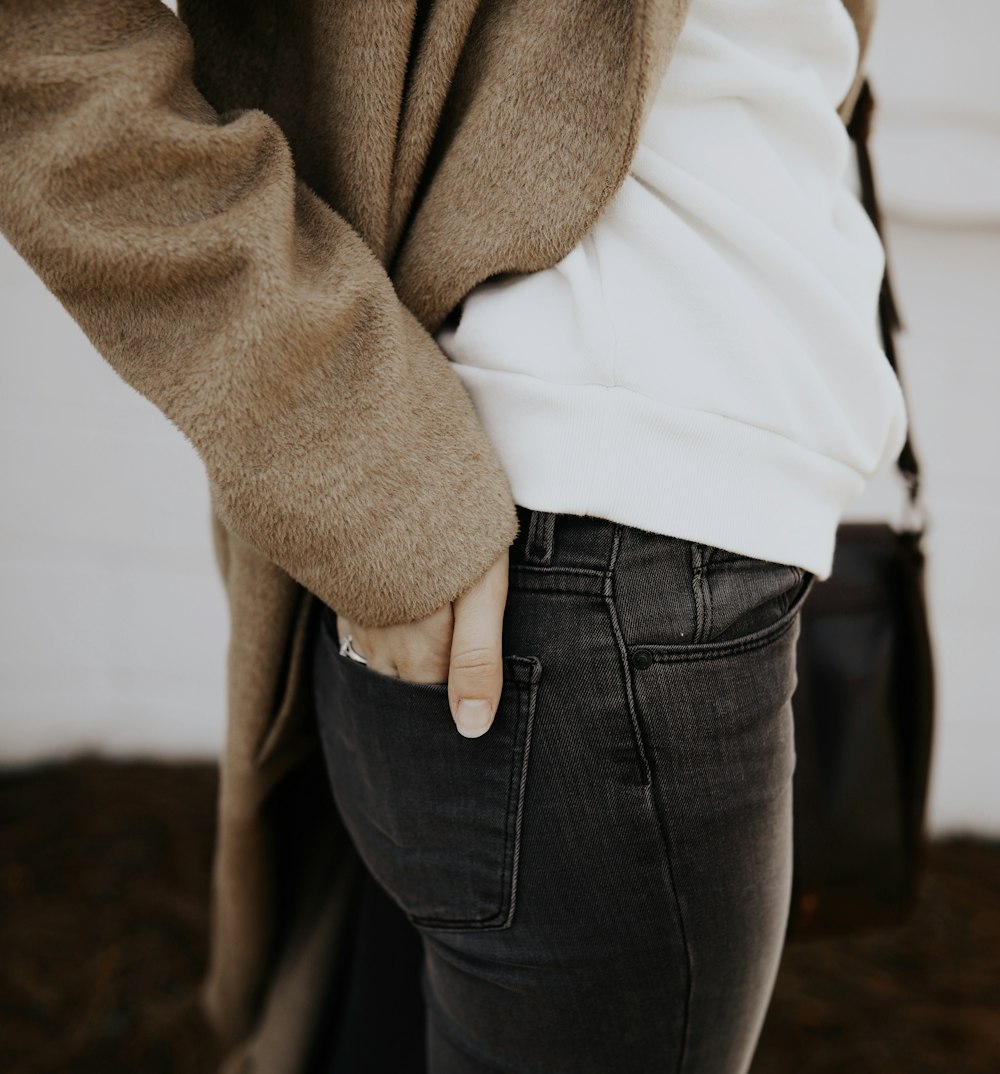 woman in brown coat and blue denim jeans