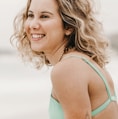 woman in teal tank top smiling