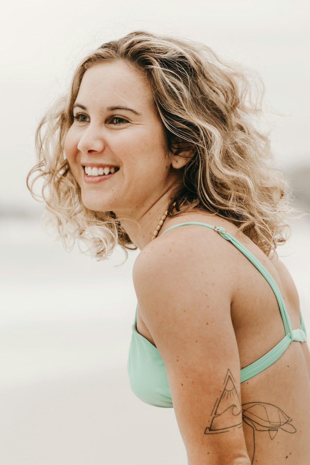 woman in teal tank top smiling