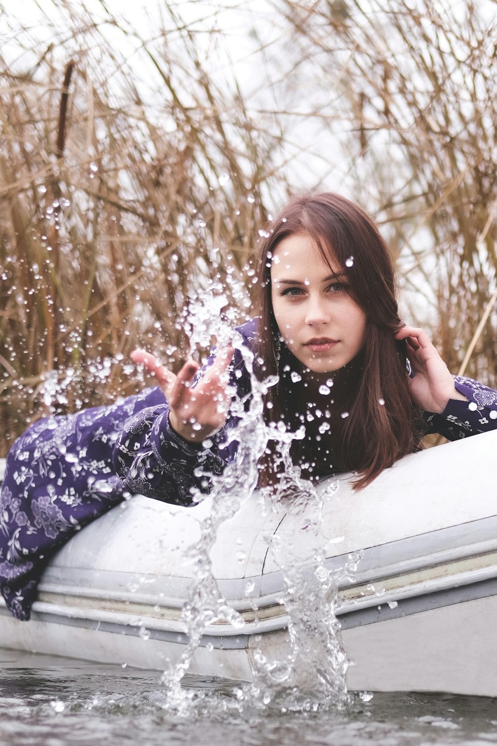 woman in blue and white floral long sleeve shirt holding snow