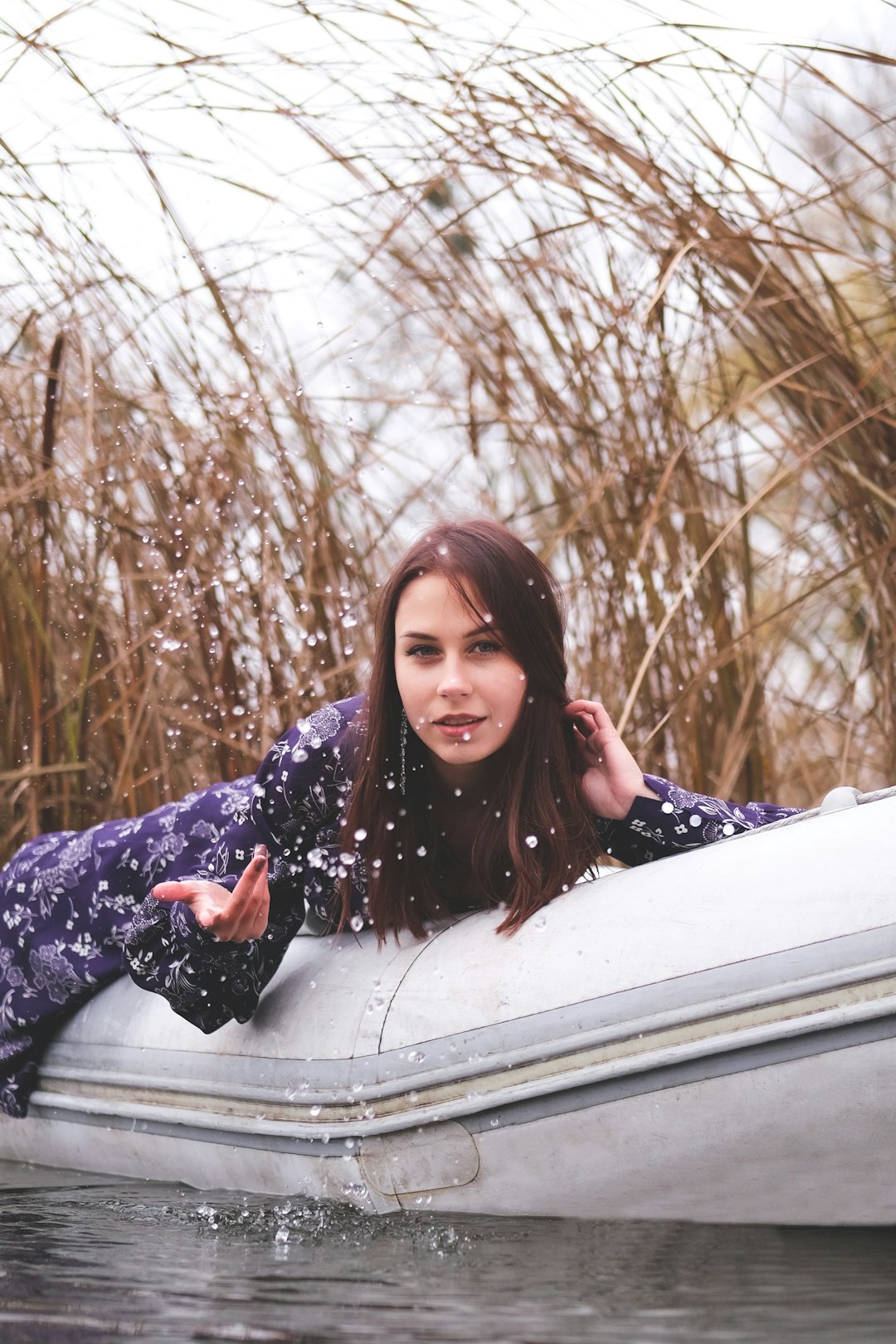 woman in black and white floral long sleeve shirt sitting on white car during daytime