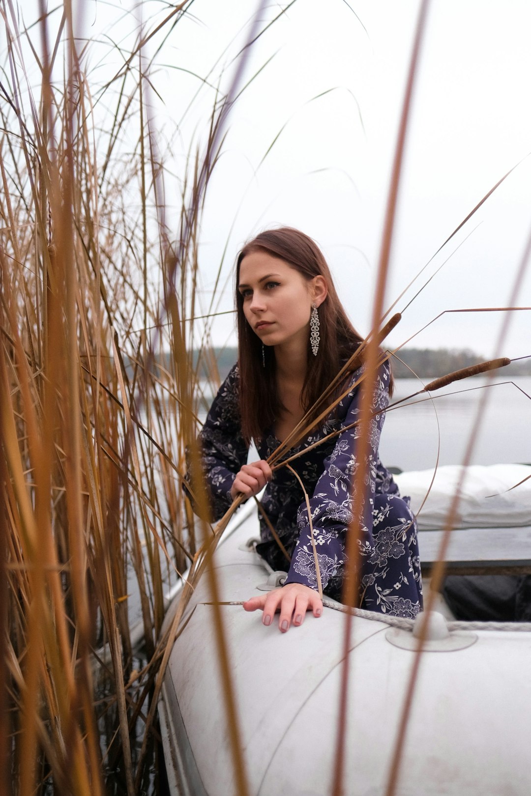 woman in black and white floral long sleeve dress standing on brown grass field during daytime