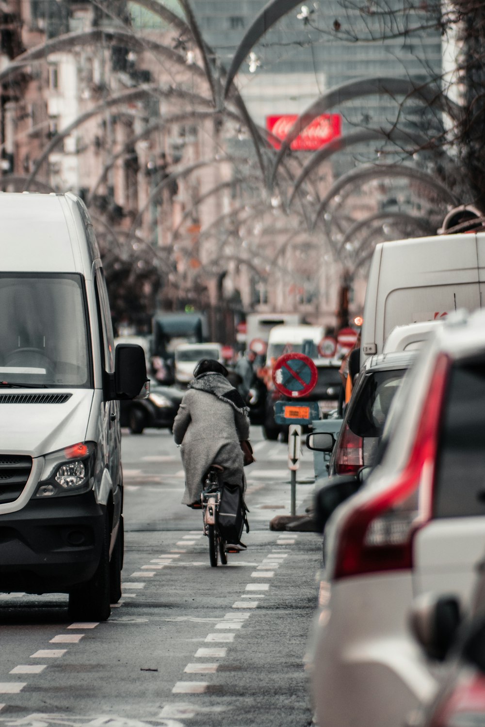 man in black jacket riding bicycle on road during daytime