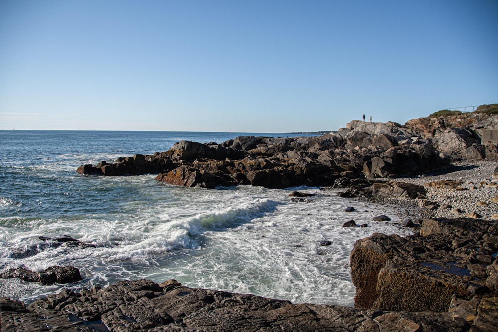 ocean waves crashing on rocky shore during daytime