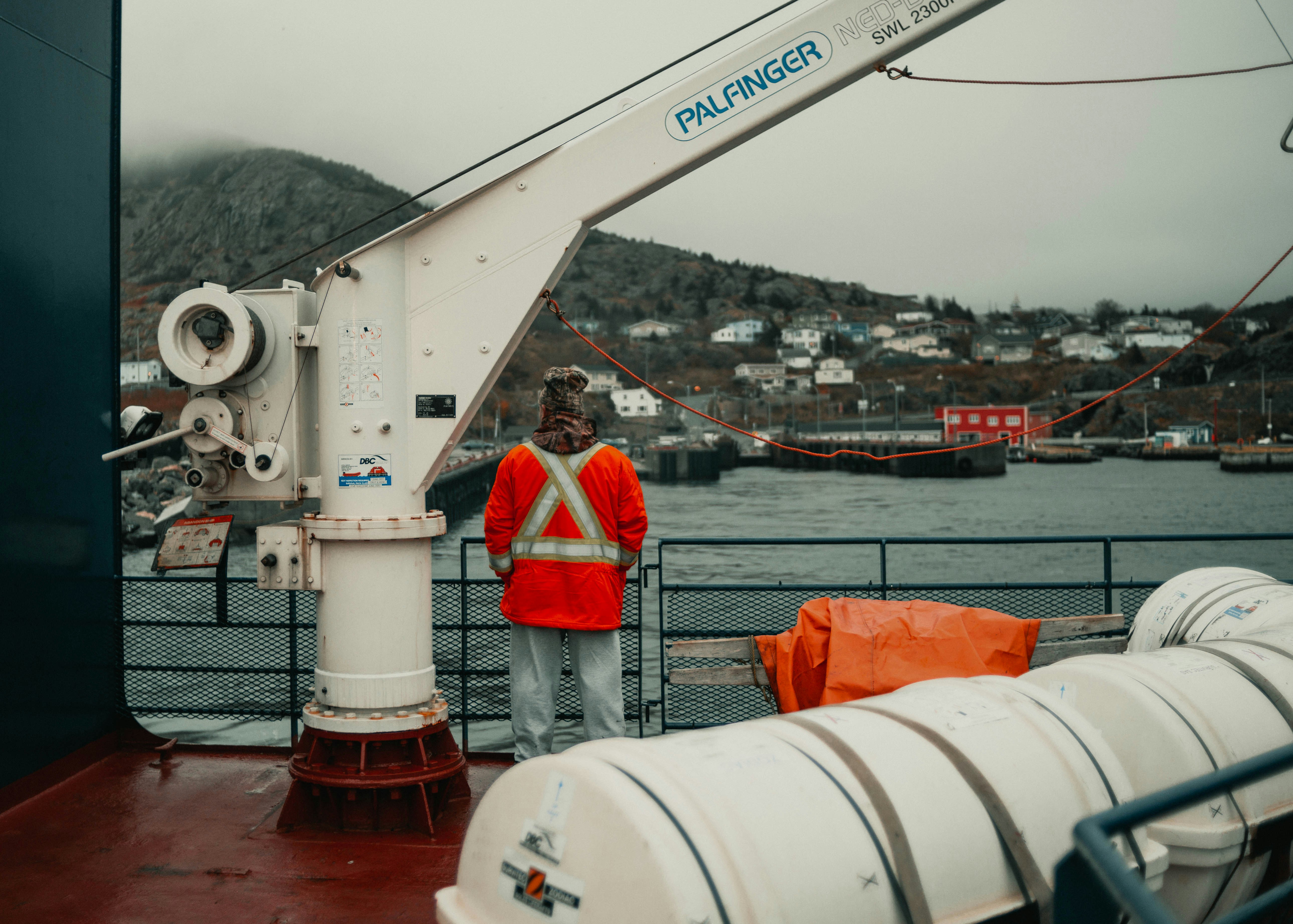 Crew member in a high-visibility vest on the deck of a vessel