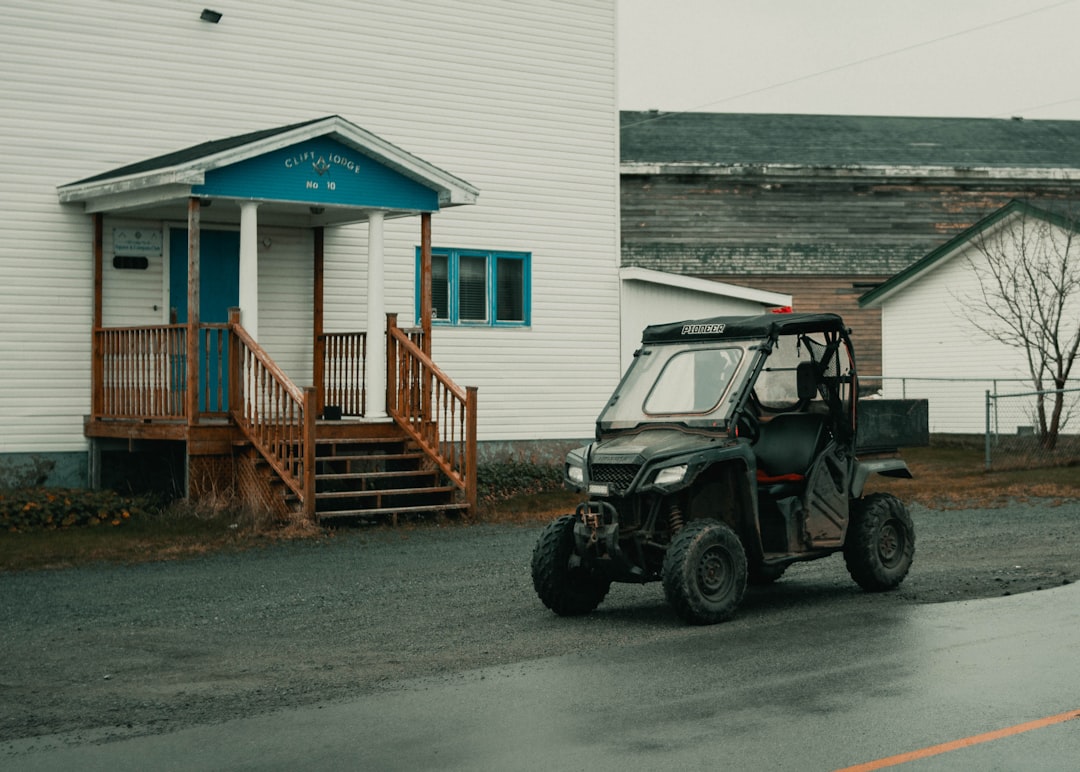 black jeep wrangler parked beside white and blue house