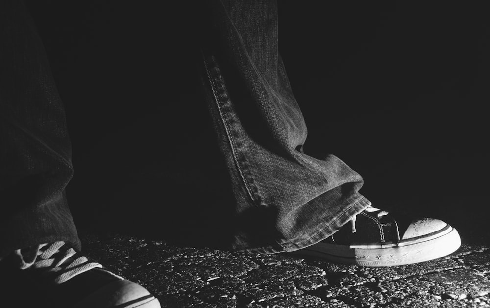 person in black denim jeans and black and white sneakers