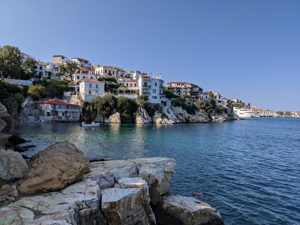 edifici in cemento bianco e marrone vicino a uno specchio d'acqua durante il giorno