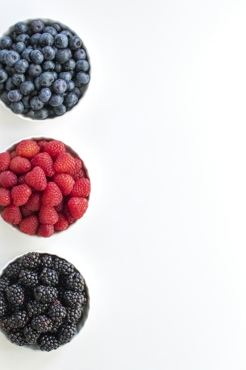 red and black berries on white surface