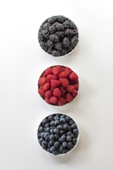 red and black berries on white surface
