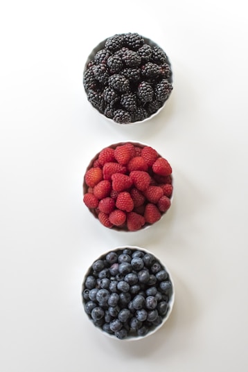 red and black berries on white surface