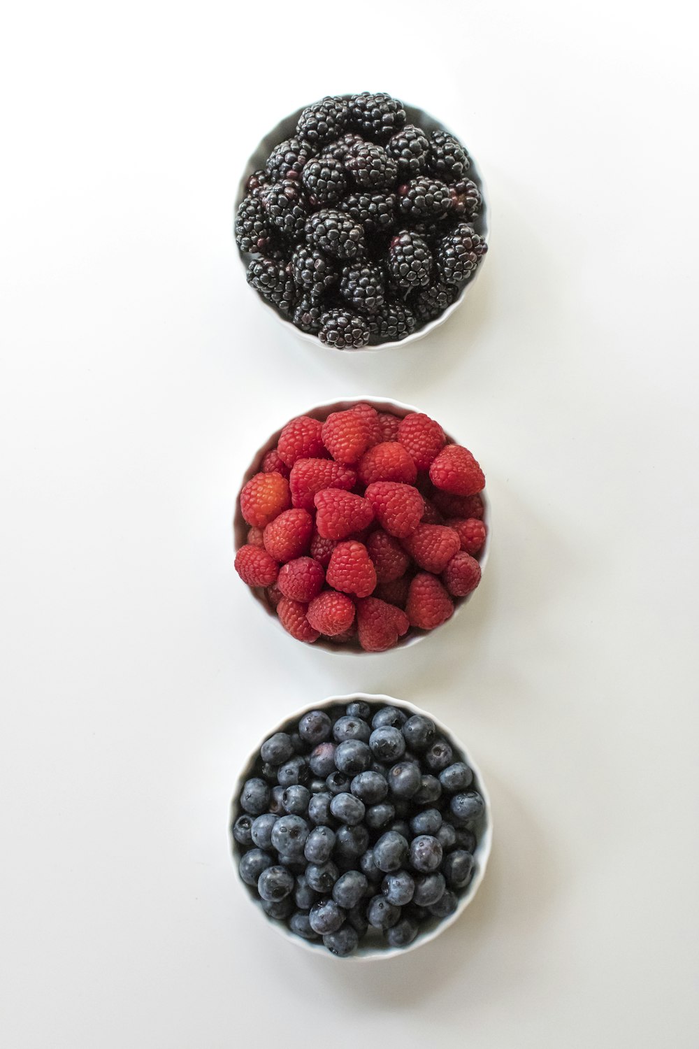 red and black berries on white surface