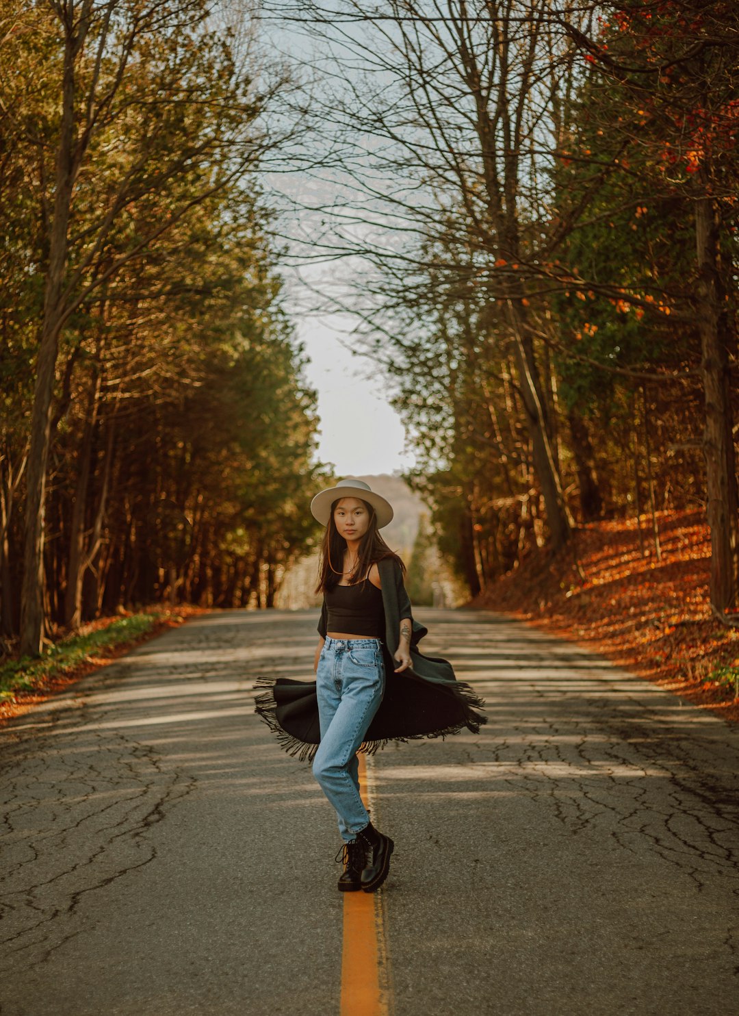 woman in black jacket and black pants standing on road during daytime