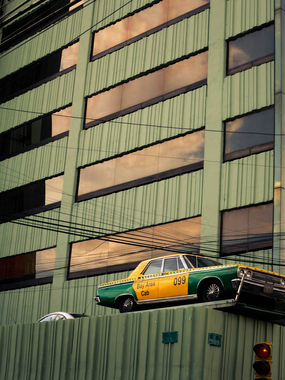 Coupé amarillo y negro estacionado junto a un edificio de concreto marrón durante el día