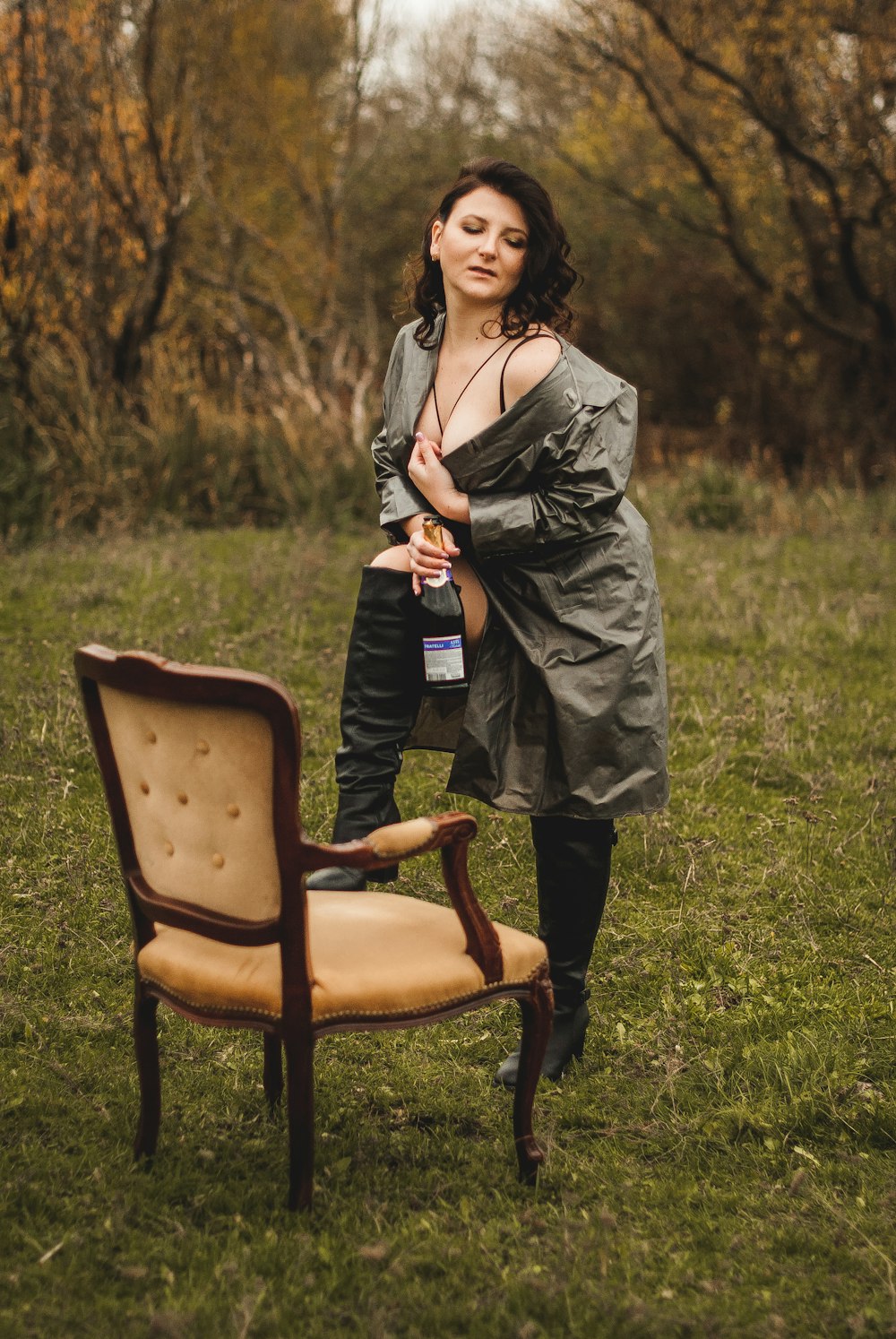 a woman standing next to a chair in a field