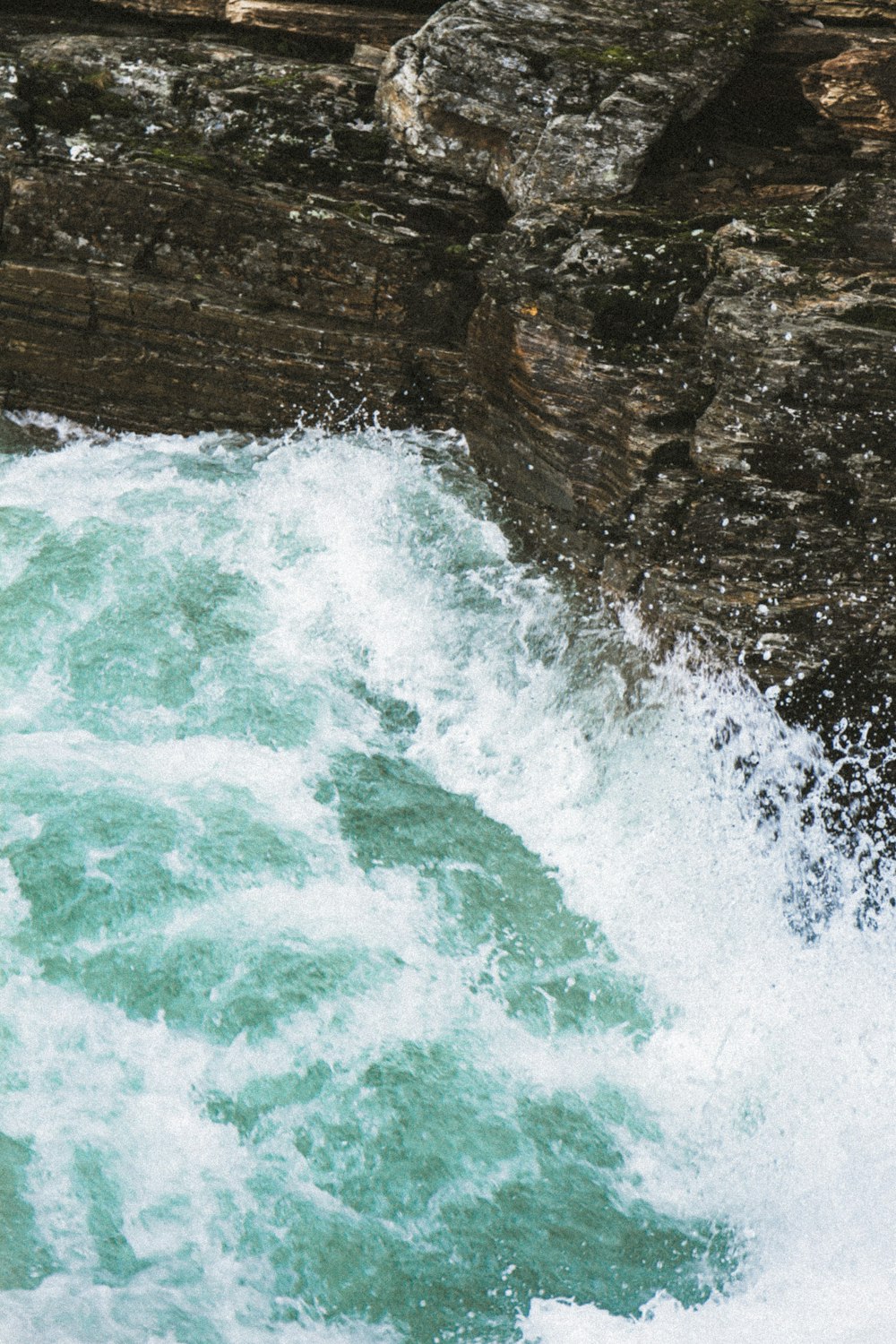 water waves hitting brown rock