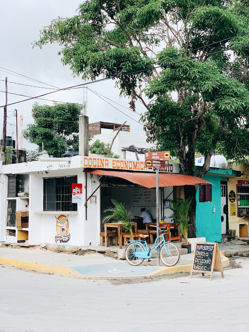 blue bicycle parked beside green and white concrete building during daytime