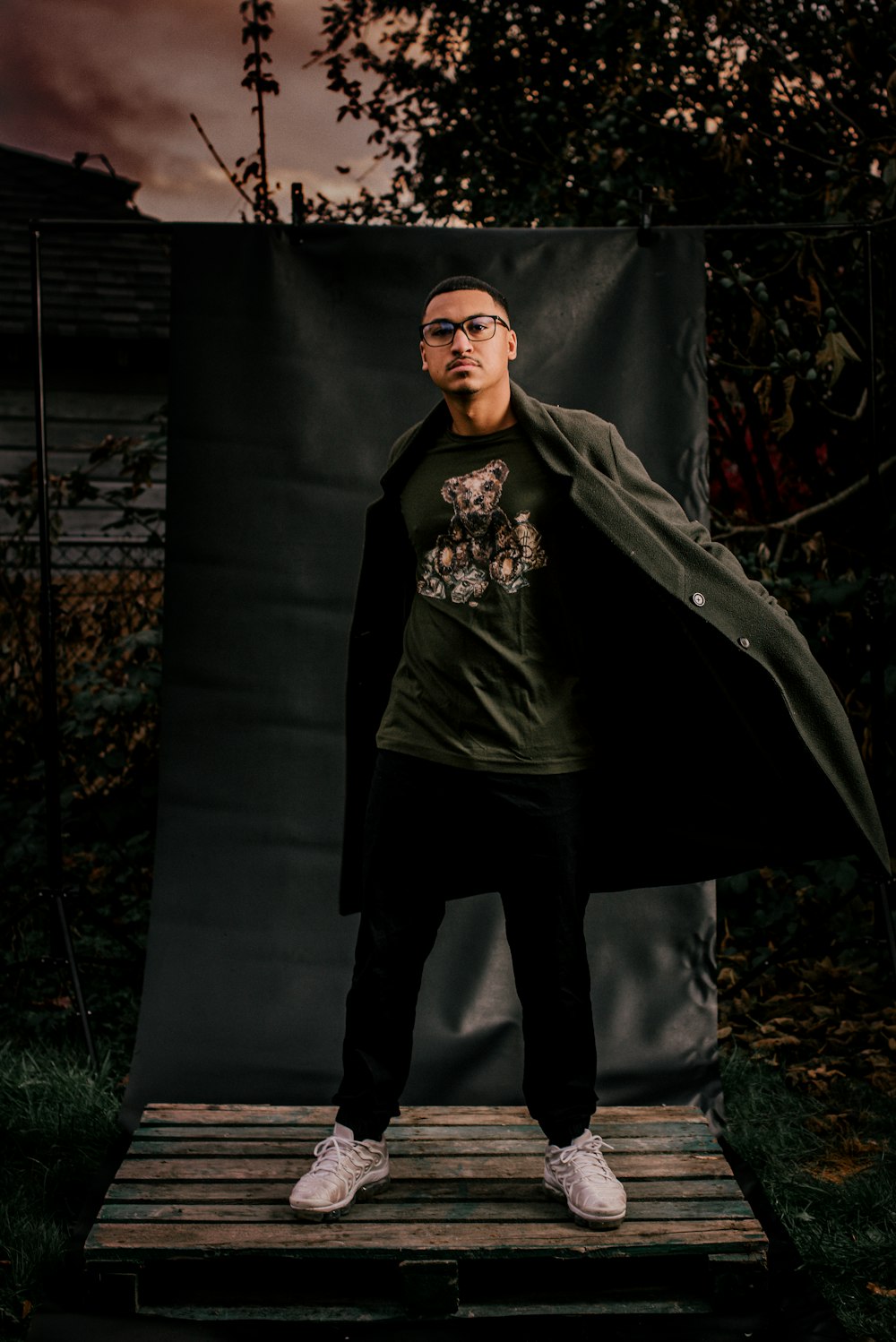 man in black hoodie standing beside black textile