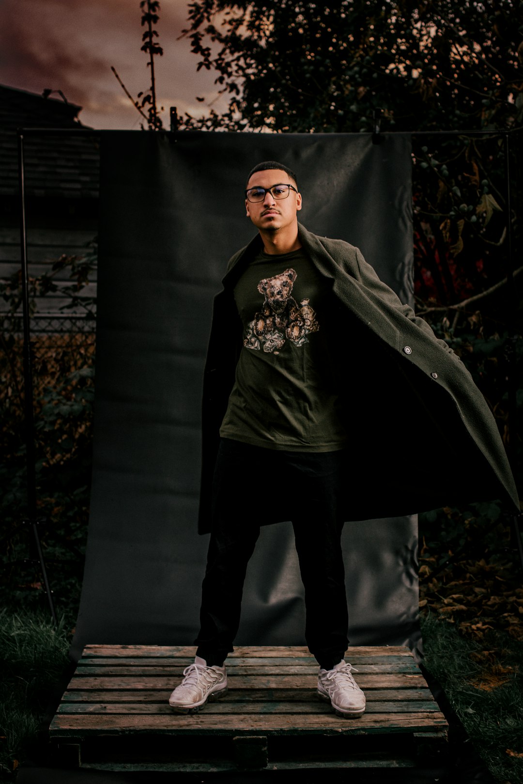 man in black hoodie standing beside black textile