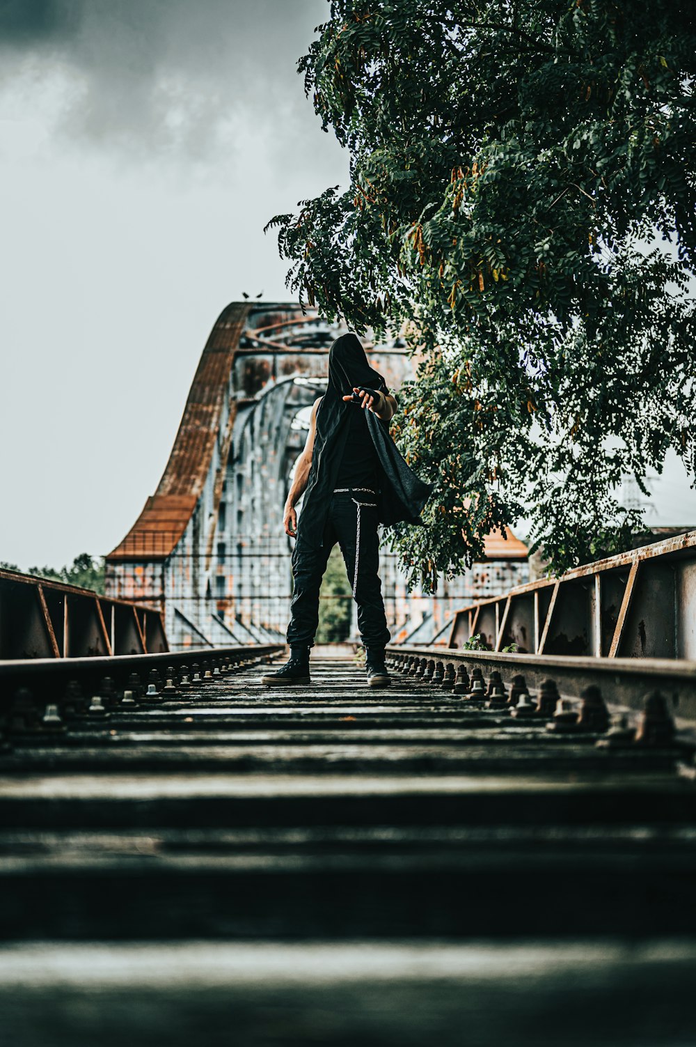 昼間、橋の上に立つ黒いジャケットの女性
