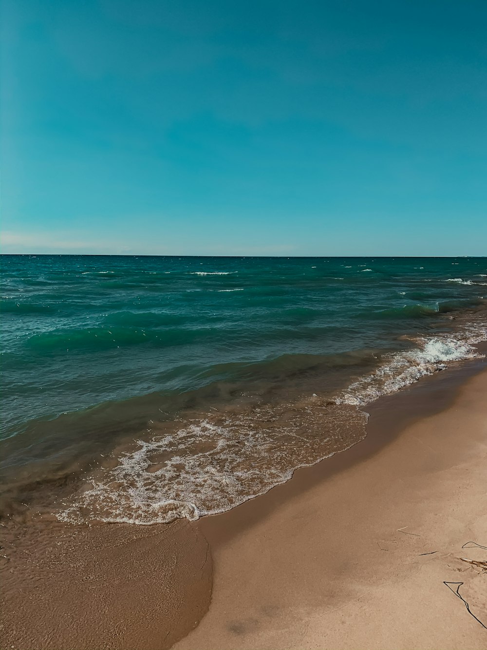 sea waves crashing on shore during daytime