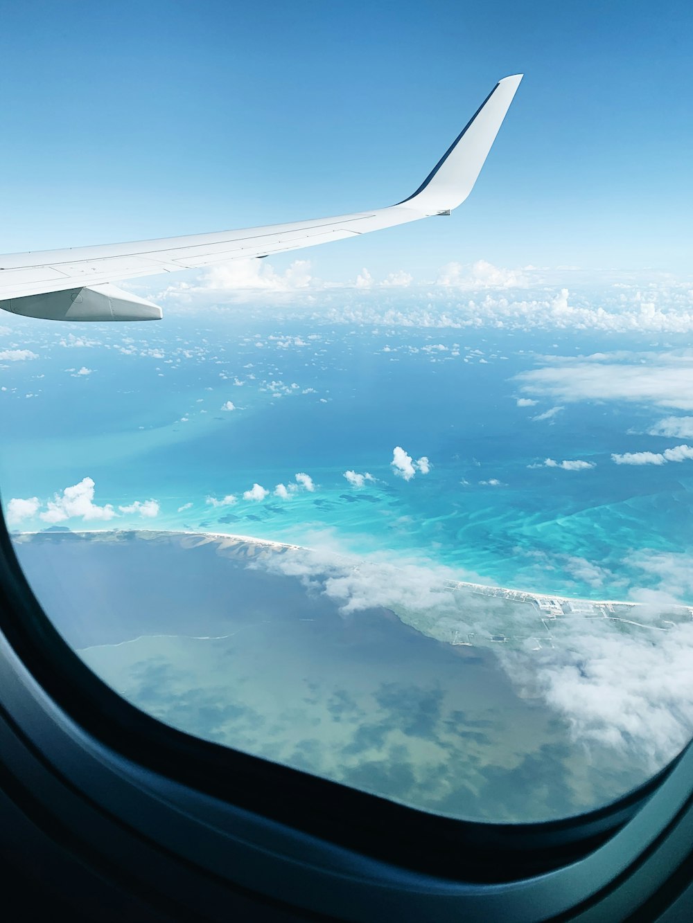 airplane window view of clouds during daytime