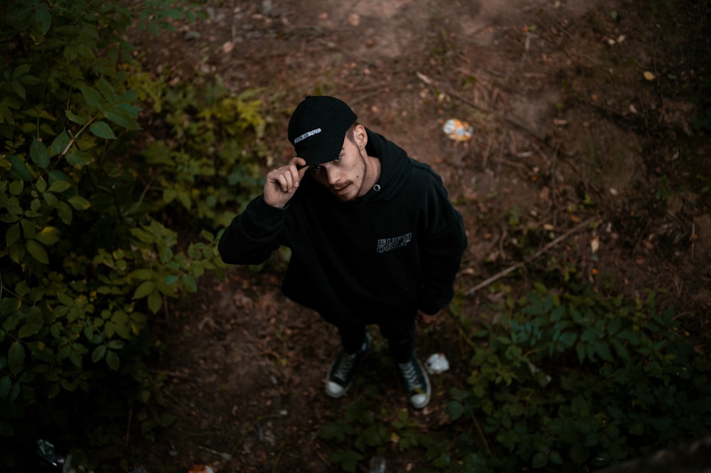 man in black hoodie and black pants sitting on ground