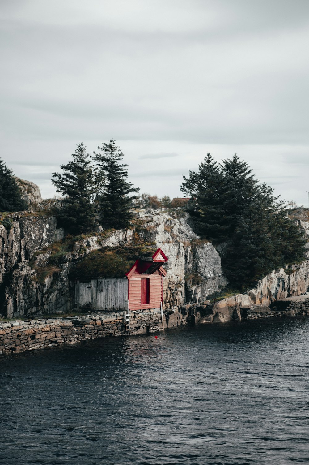 red and white house near body of water during daytime