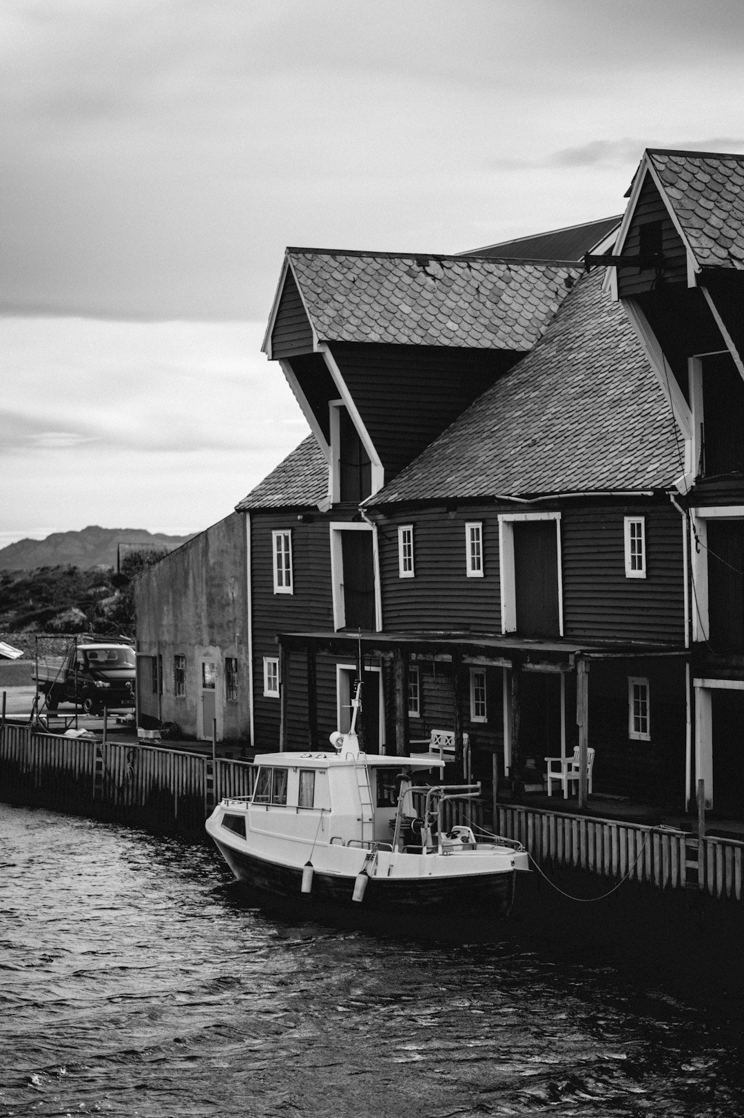 grayscale photo of a house near body of water