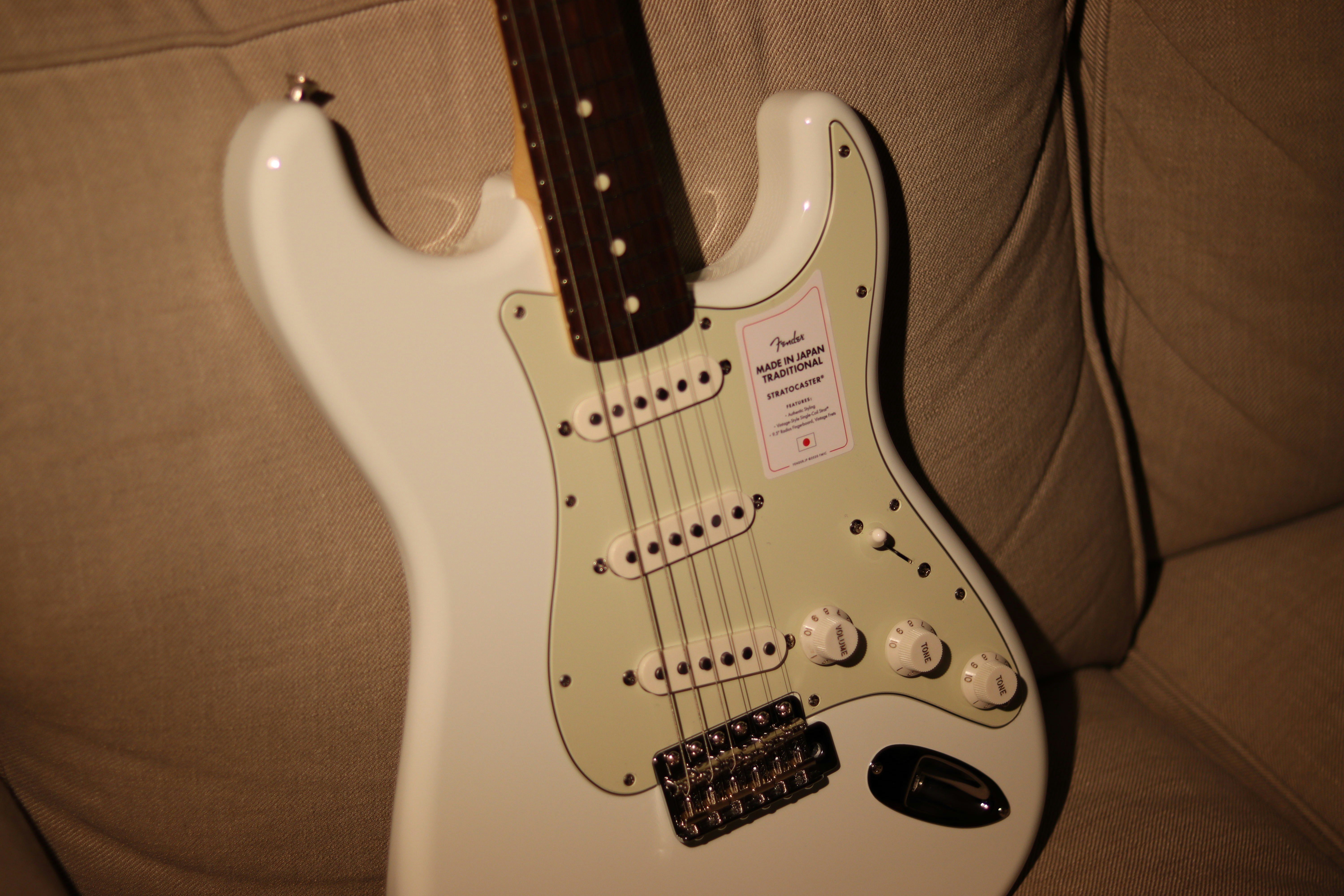 white and brown stratocaster electric guitar