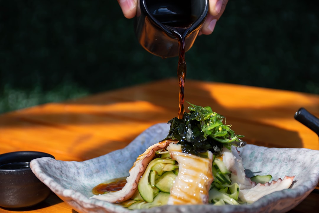 person holding black ceramic mug with green vegetable