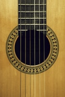 brown acoustic guitar on brown wooden table
