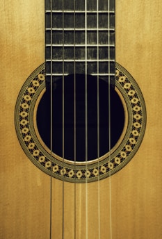 brown acoustic guitar on brown wooden table